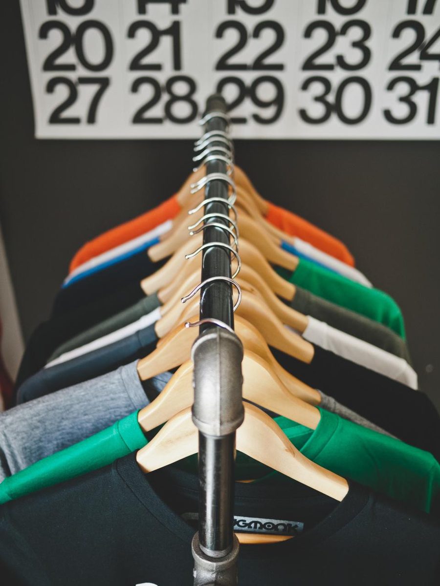 Peças de roupa prontas em cabides no ateliê